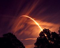 SpaceX Falcon 9 arcs through a veil of clouds